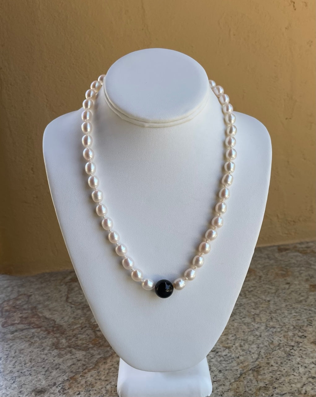 Necklace - Knotted white rice pearls with black onyx as a focal point